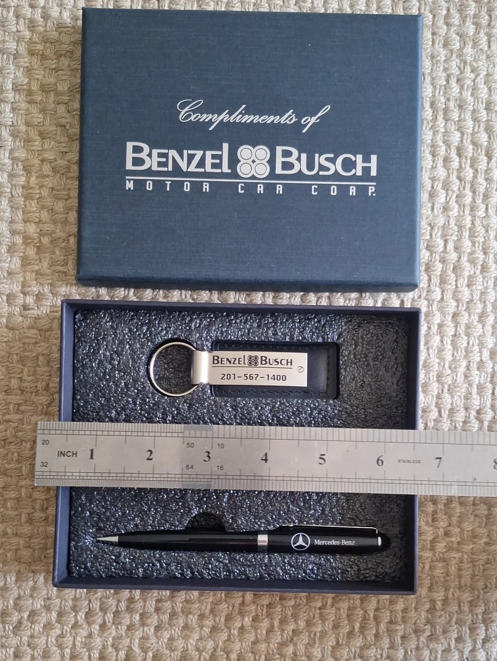 The seMercedes-Benz branded gift set featuring two keychains and a ballpoint pen